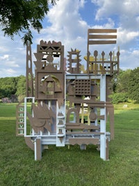 a large cardboard structure in the middle of a grassy field